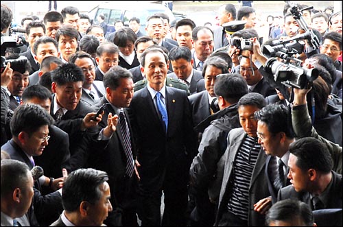 13일 "해군기지 철회하라"는 구호를 뒤로 한 채 경호를 받으며 제주도 청사로 들어가는 김장수 국방부 장관. 